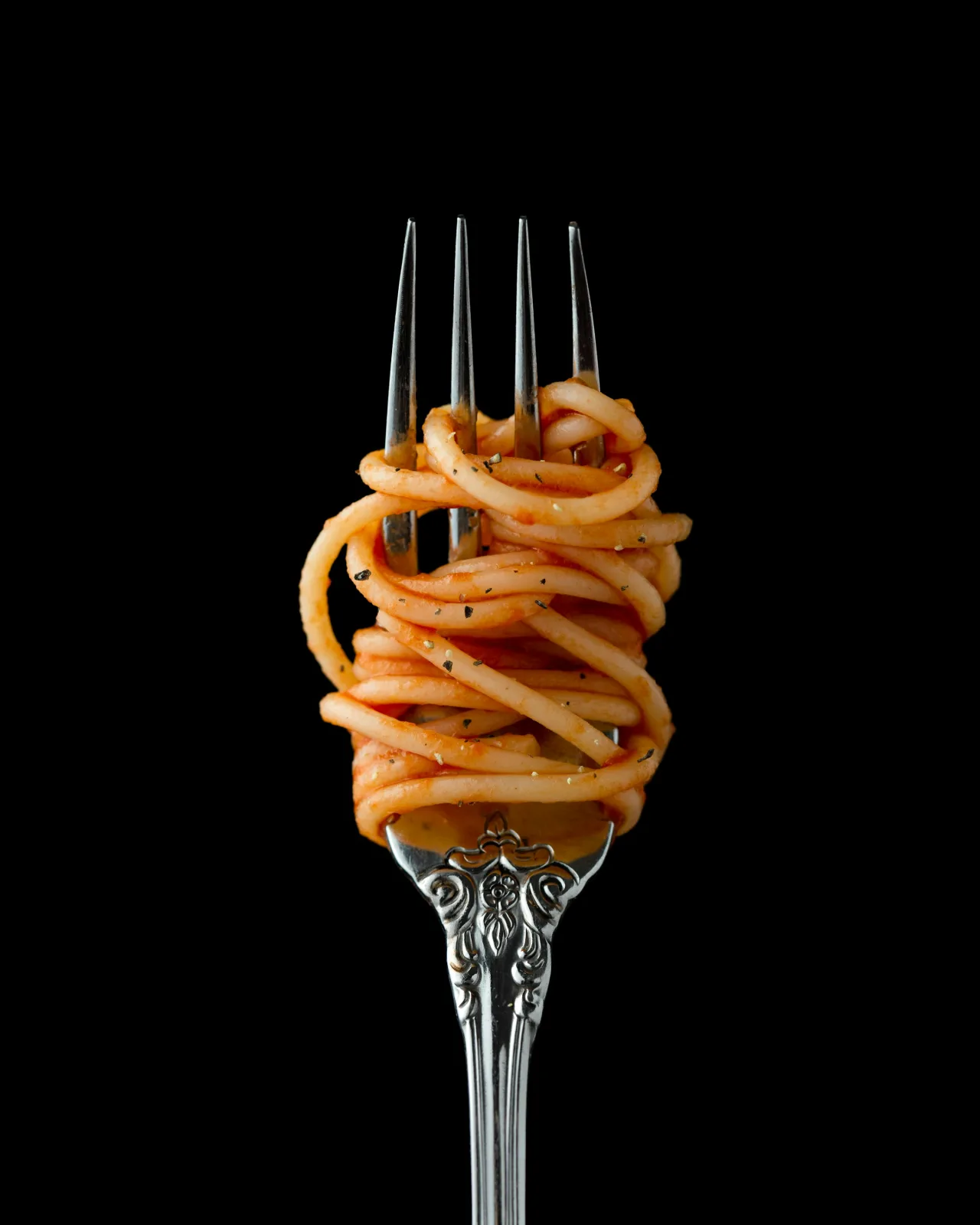 Un boccone di pasta al pomodoro su una forchetta